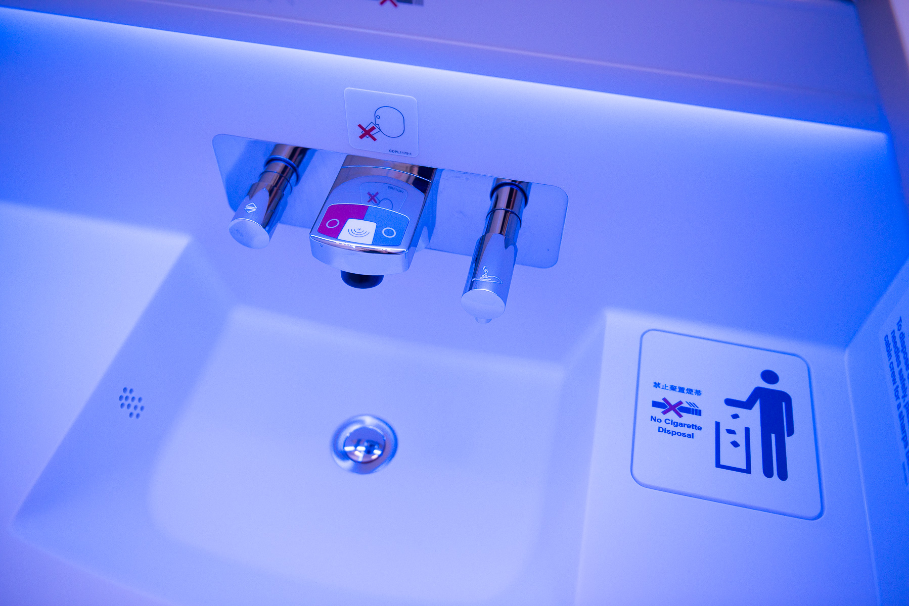 Airplane lavatory sink bathed in blue light