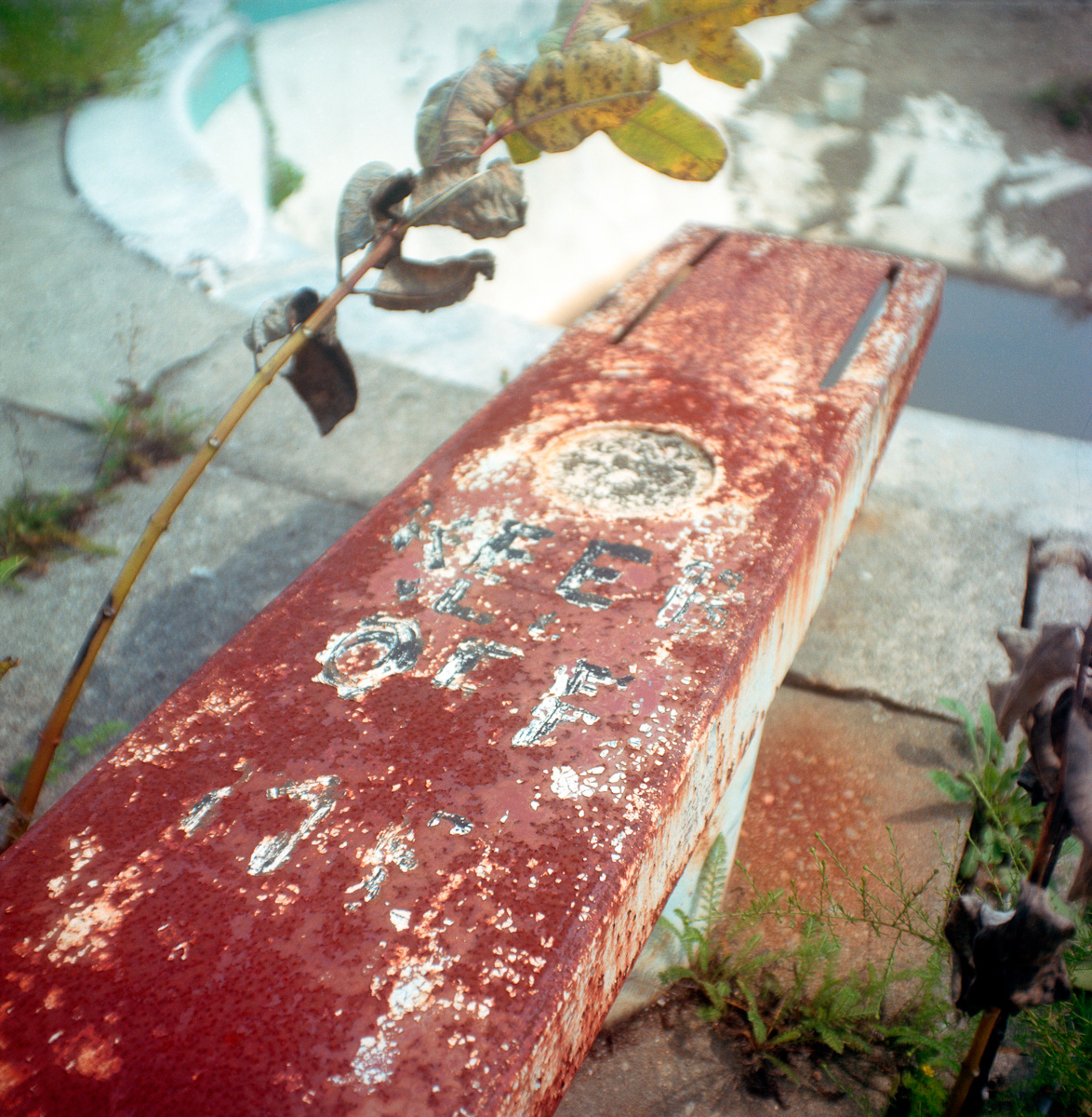 Keep Off - rusty diving board at an abandoned pool 