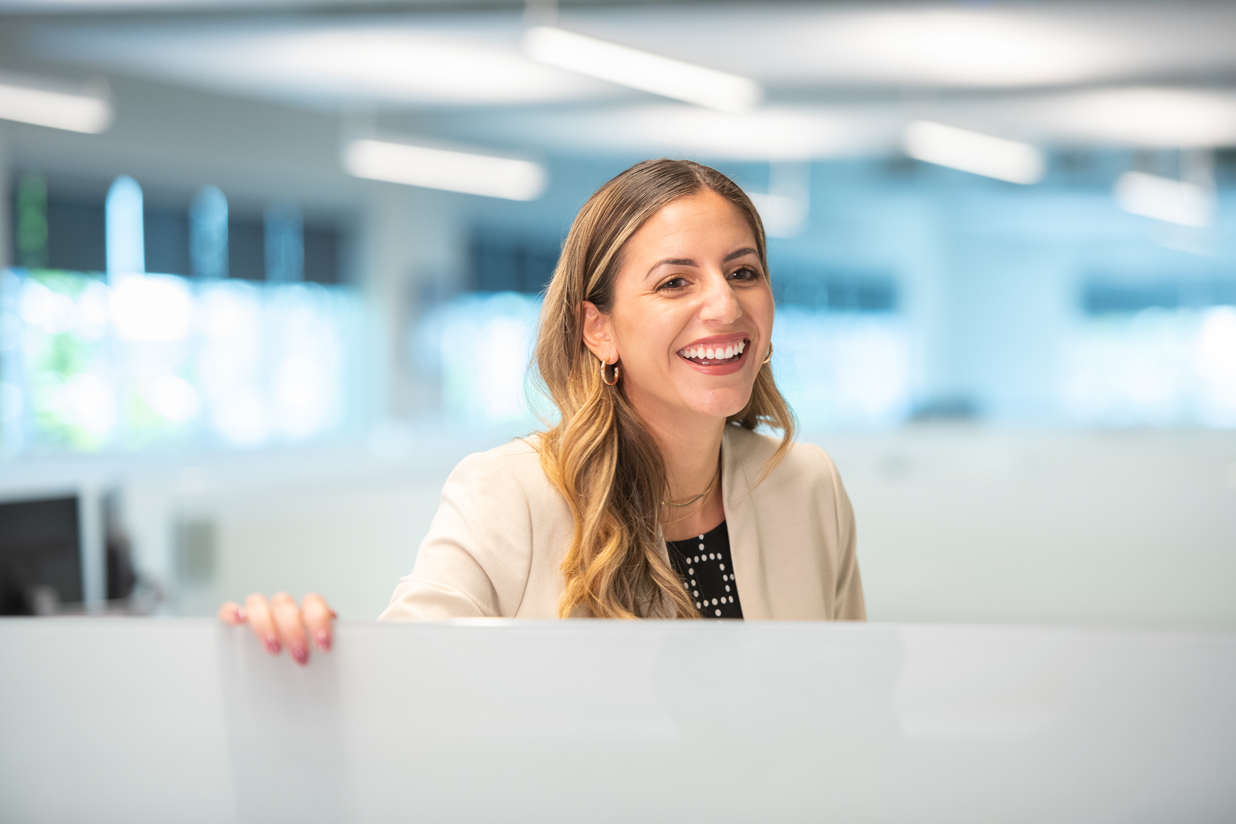 Woman smiles in corporate office cubicle