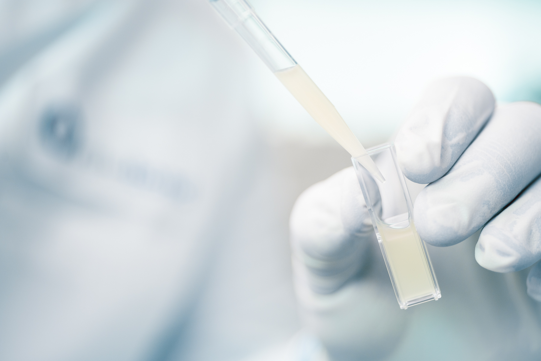 Cloeup of biotech pipette into lab vial