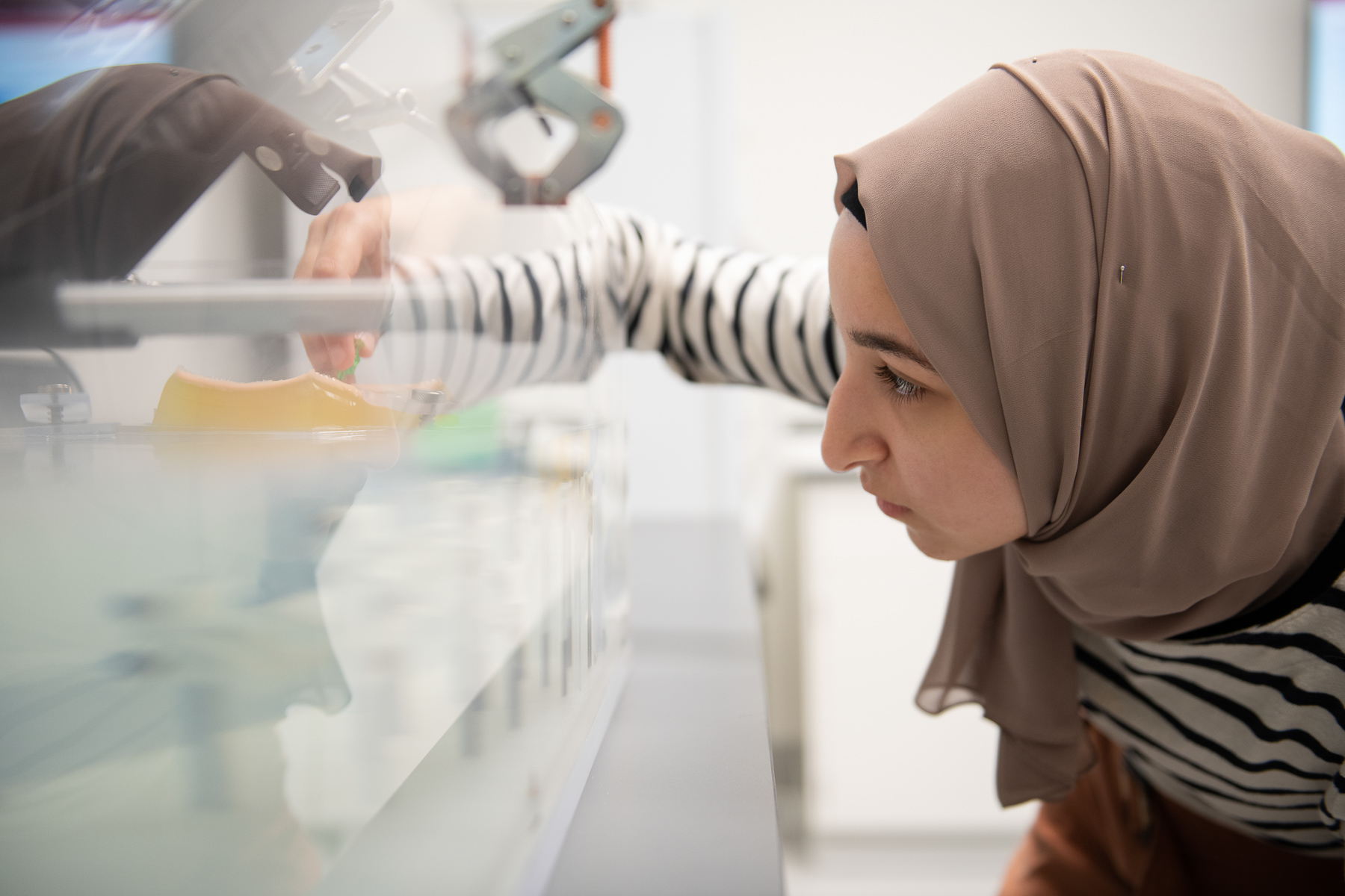 Female Scientist with headscarf performs experiment