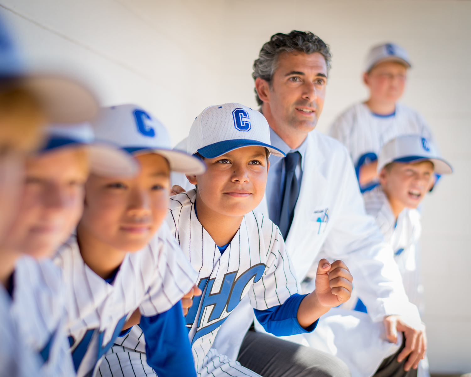 Little League boys in dugout with Doctor